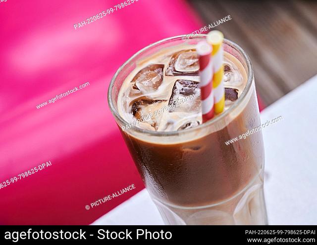 25 June 2022, Berlin: Ice cubes float in an iced coffee sitting on a terrace in a café. The heat is sweltering in Berlin on the weekend