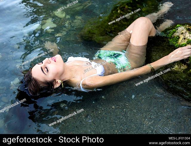 Young woman with closed eyes in water