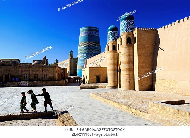 Children playing near the Kuhna Ark fortress and the unfinished minaret Kalta Minor. Uzbekistan, Khorezm, Khiva, Itchan Kala (inner town)