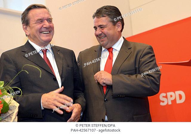 Former German Chancellor Gerhard Schroeder (SPD, L) and the SPD'S Chairman Sigmar Gabriel talk to each other and smile during a ceremonial act of the...