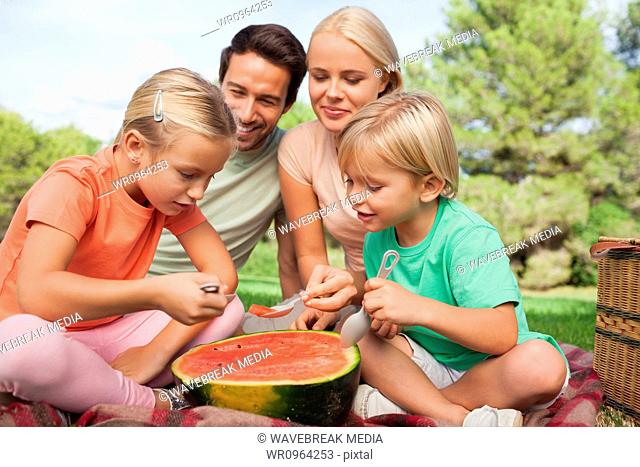Happy family having watermelon at a picnic
