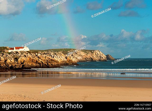 Baleal beach with atlantic ocean and rainbow in the sky and seagulls on the sand in Peniche, Portugal