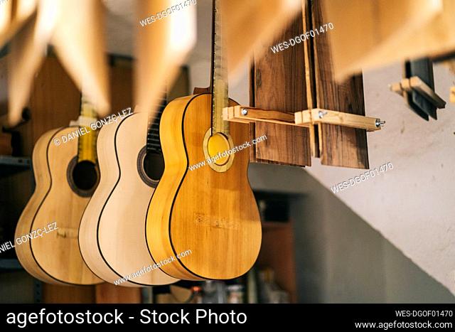 Guitars hanging in a line at workshop