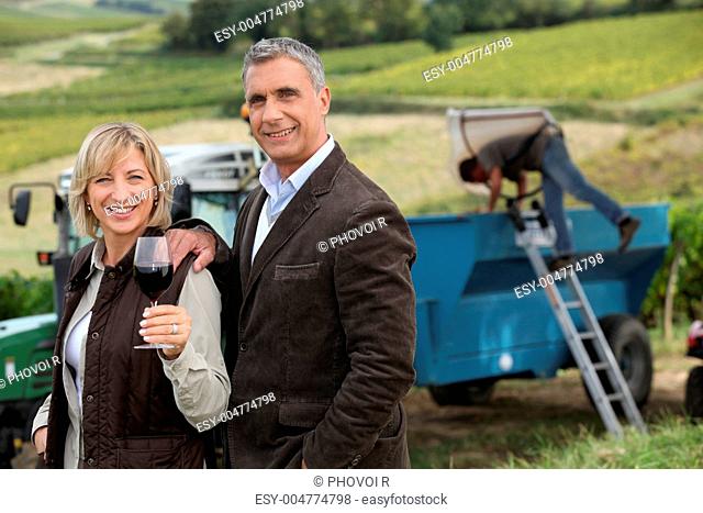 Farmer and wife in front of equipment