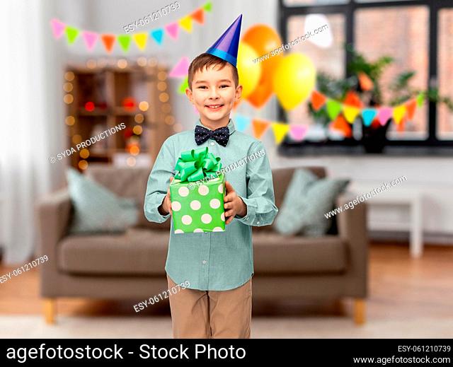 smiling boy in party hat with birthday gift