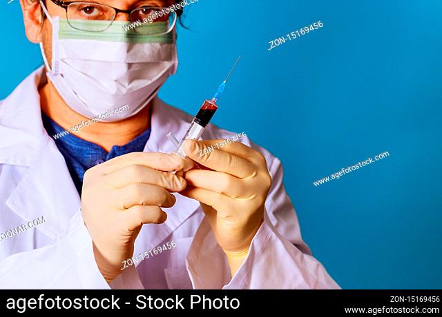 Hand of medical doctor holding syringe blood sample inside in the laboratory