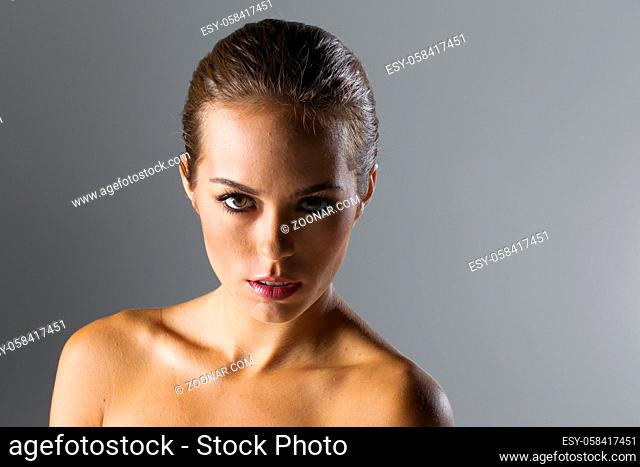 A beautiful brunette model posing in a studio environment
