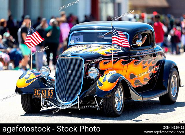 Benton Harbor, Michigan, USA - May 4, 2019: Blossomtime Festival Grand Floral Parade, Hot road carrying the american flag, going down the road during the parade