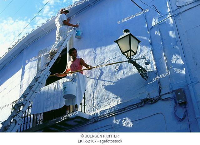Whitewashing a house in Frigliana, white village, Province Malaga, Andalusia, Spain