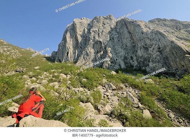 Mountain rescuer in front of the cliffs of Velika Paklenica canyon in Paklenica National Park, Croatia, Europe