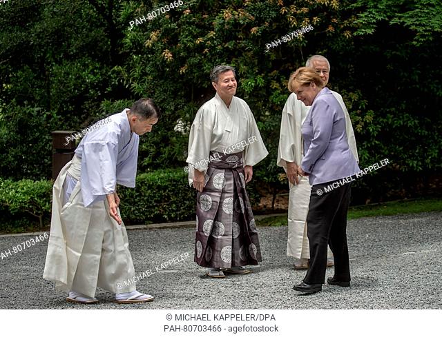 German Chancellor Angela Merkel (CDU) being welcomed by Shinto priests at the garden of the Ise shrine in Ise-Shima, Japan, 26 May 2016