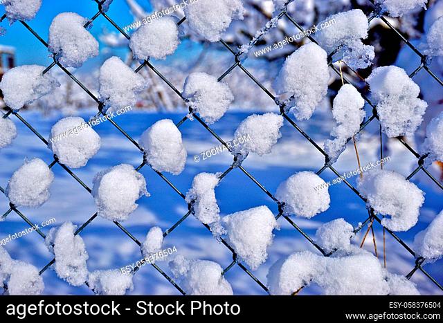 Maschendrahtzaun mit Schnee bedeckt, Chain link fence covered in snow