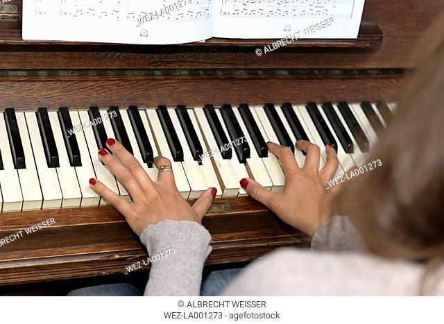 Young woman playing piano, musical notes