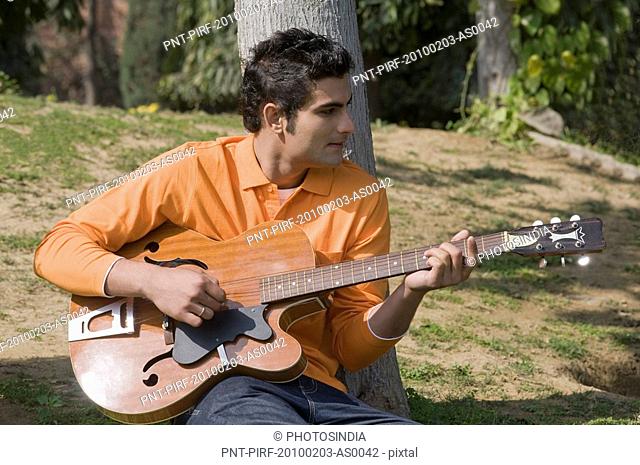 Man playing a guitar in the garden