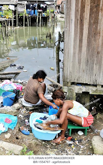 Two young women, Afro-Colombians, doing laundry on the waterfront in the Bajamar slum, Buenaventura, Valle del Cauca, Colombia, South America