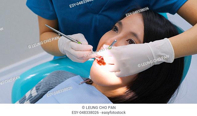 Asian Woman undergo check up of tooth in dental clinic