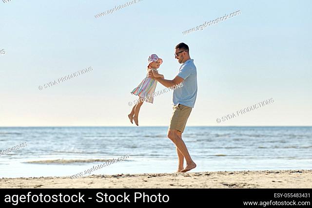 happy father playing with little daughter on beach