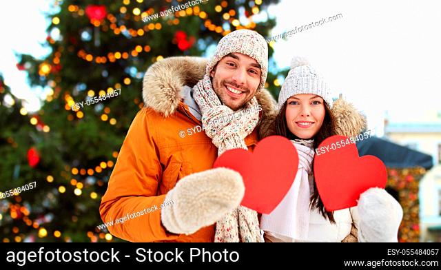 happy couple with red hearts at christmas market