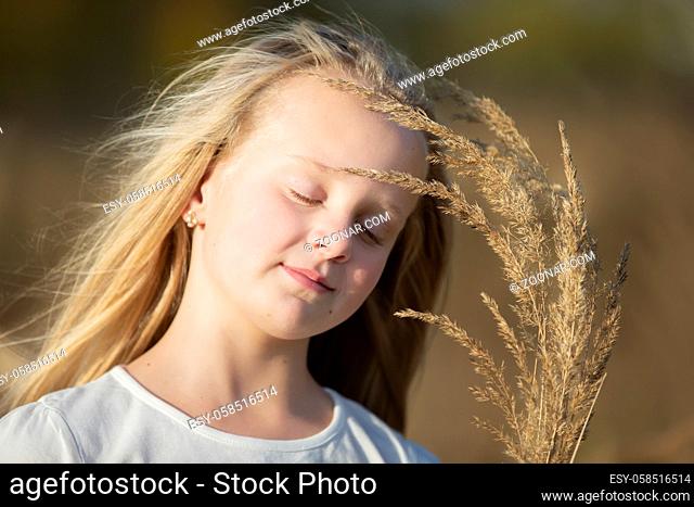 Beautiful little blonde girl with a bouquet of herbs.Child in a beautiful summer field