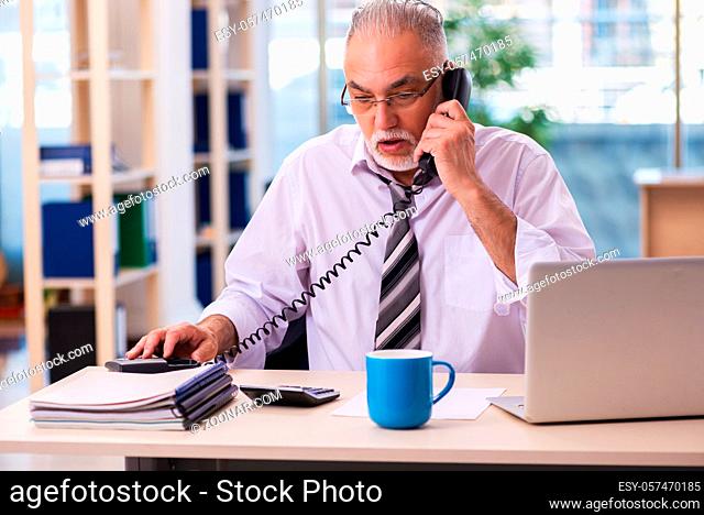 Old businessman employee unhappy with excessive work