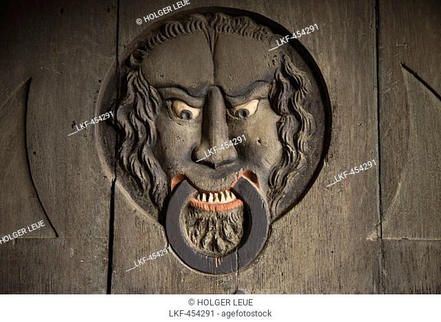 Doorknocker carving on a wooden gate to Schrotturm tower, Schweinfurt, Franconia, Bavaria, Germany
