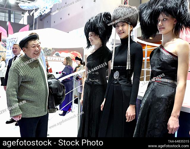 RUSSIA, MOSCOW - NOVEMBER 15, 2023: A visitor and models in fancy costumes at the opening of Buryatia Day at Pavilion No