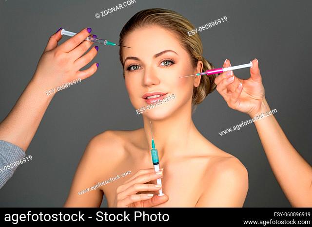 beautiful young woman getting beauty injections. spa procedure. studio shot. copy space
