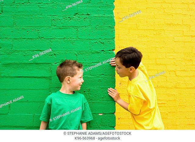 Two boys against yellow and green wall