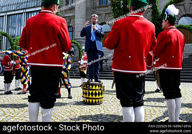05 May 2022, Bavaria, Munich: Schäffler dance in the Hofgarten in front of the State Chancellery and are welcomed by Markus Söder (CSU)