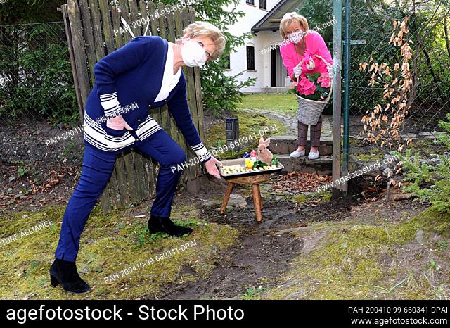 09 April 2020, Bavaria, Munich: The presenter Carolin Reiber (l) exchanges Easter presents with her neighbour Margot Steinberg at the appropriate distance