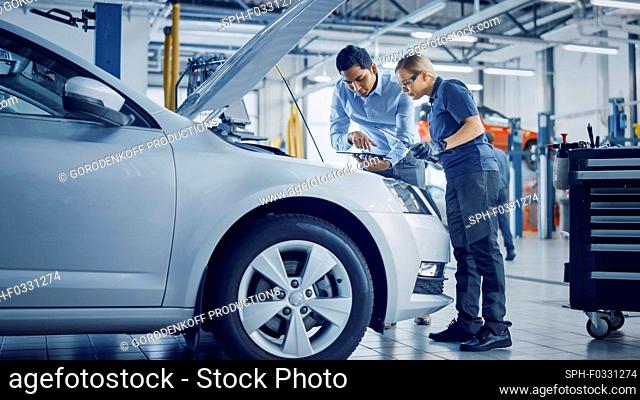 Mechanic and service manager inspecting a car