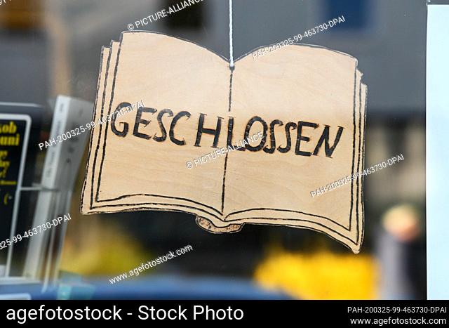25 March 2020, Hessen, Kassel: A ""Closed"" sign hangs in the entrance to a bookstore. The Corona crisis continues to have Hesse and the world firmly in its...