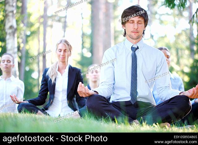 Business people team practicing yoga in park