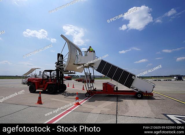 09 June 2021, Hamburg: Aircraft handler Erdogan Sati practices docking a passenger staircase onto an Airbus A320 on the apron