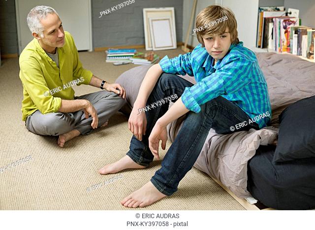 Man sitting with his son looking upset