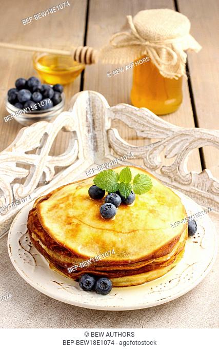 Stack of pancakes with syrup and blueberries. Summer party dessert