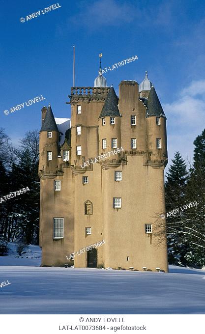 Grampian. Square tall castle with pointed round towers. Small windows. Snow on ground