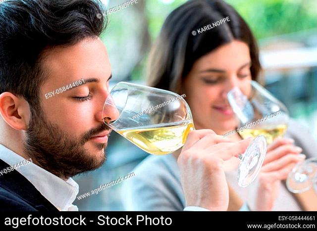 Close up portrait of young couple tasting white wine tasting