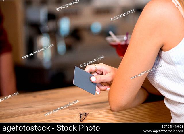 Young Beautiful Girl Standing At Stand Up Bar And Holding Credit Card. Going To Pay In Cafe