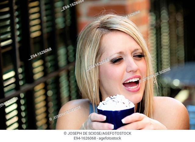 31 year old blond woman holding a coffee mug in a cafe