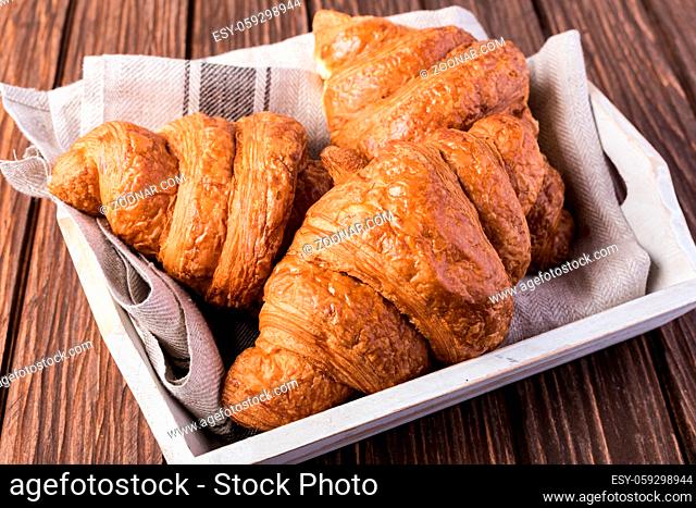 freshly baked croissants on wooden table