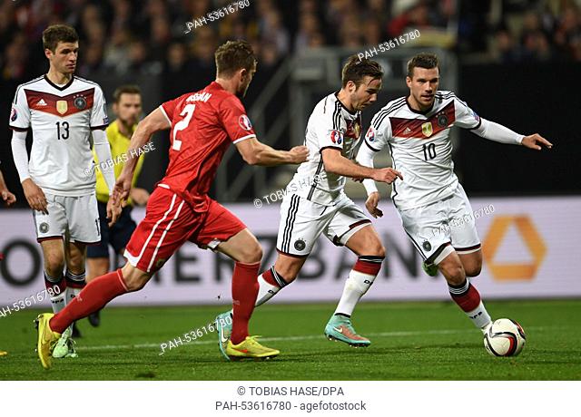 Germany's Lukas Podolski (R-L), Mario Goetze and Gibraltar's Scott Wiseman (C) in action during the European Cup qualification match between Germany and...