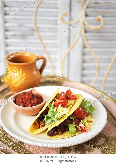 Tacos filled with chili con carne, salad and cheese