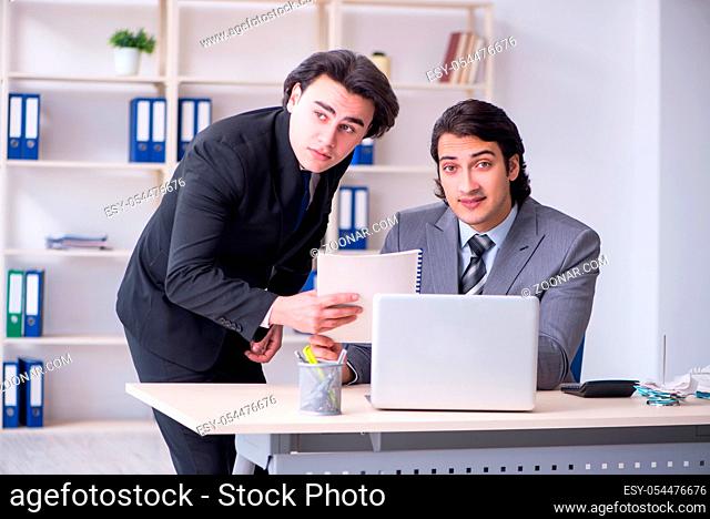 The two young employees working in the office