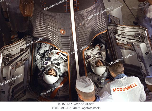 Astronauts L. Gordon Cooper Jr. (left) and Charles Conrad Jr. are seen in the Gemini-5 spacecraft in the white room at Pad 19 just after insertion