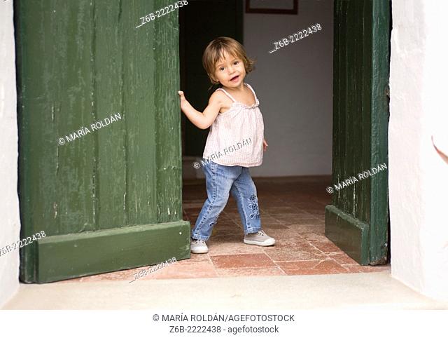 2 years old baby girl at the door, Menorca, Spain
