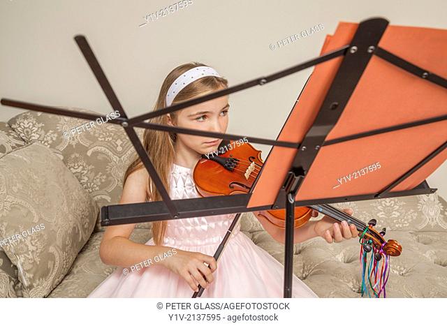Preteen blond girl practicing the viola