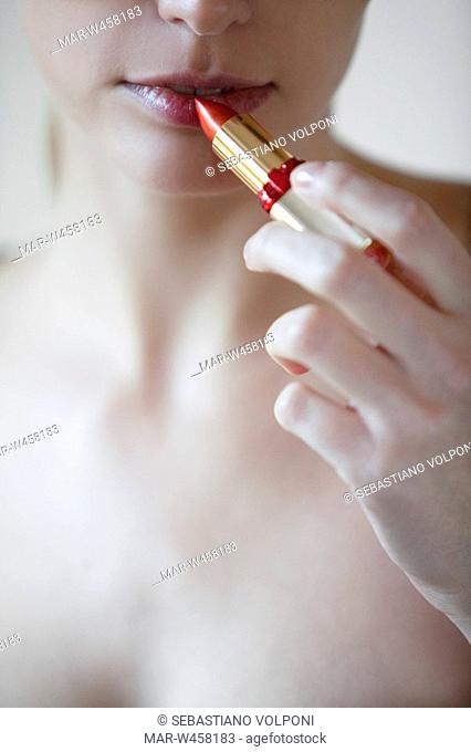 woman puts on lipstick