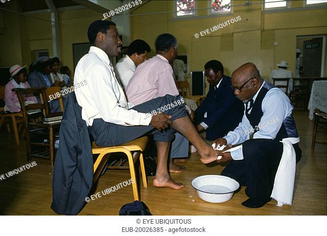 Pentecostal church service. Members of the congregation taking part in the washing of feet ceremony