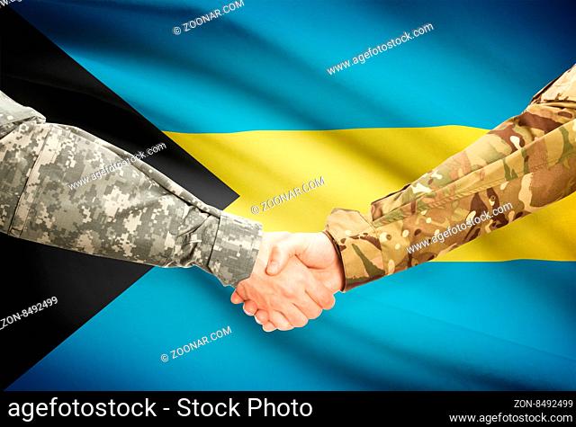 Soldiers shaking hands with flag on background - Bahamas